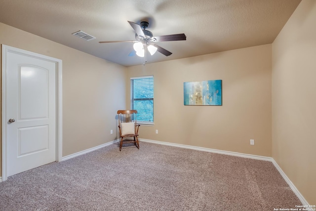 unfurnished room featuring a textured ceiling, carpet flooring, visible vents, baseboards, and a ceiling fan