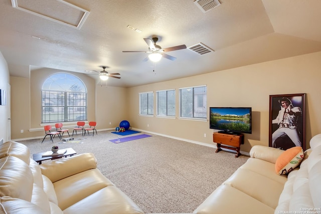 carpeted living area with attic access, visible vents, baseboards, and a ceiling fan