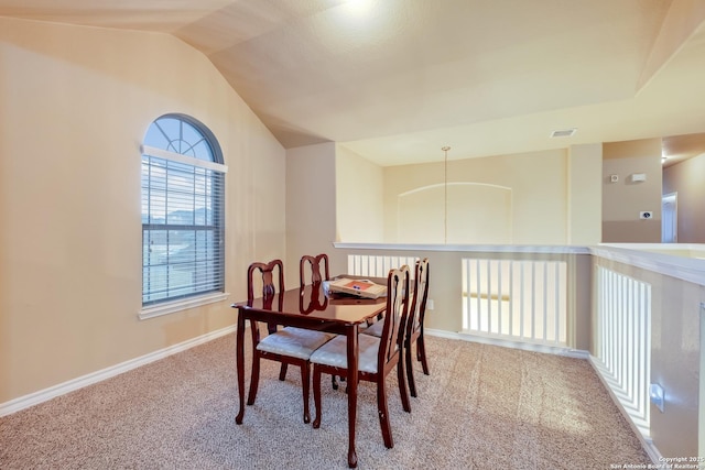 carpeted dining area featuring lofted ceiling, baseboards, and visible vents