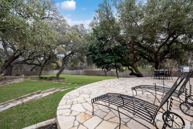 view of community featuring a patio, a lawn, and a fenced backyard