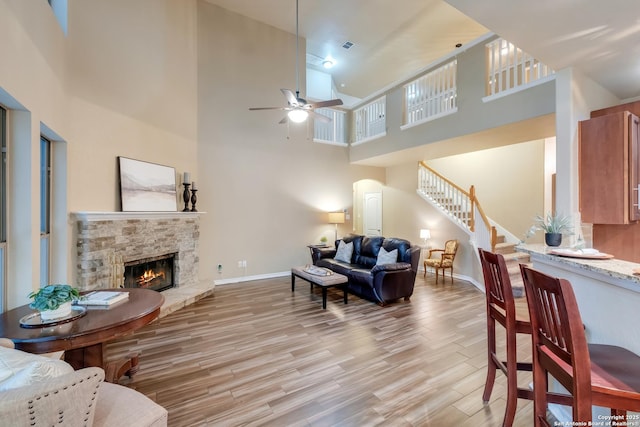 living area with light wood finished floors, stairs, baseboards, and a fireplace