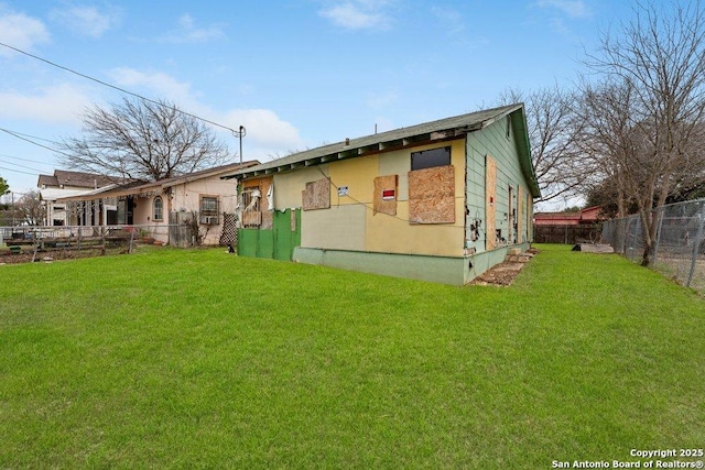 back of property featuring fence and a lawn