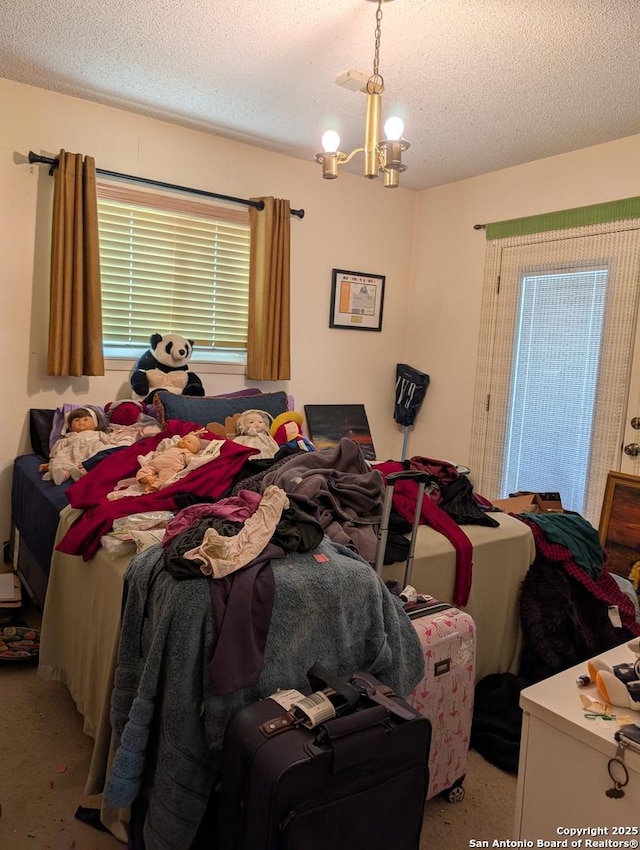 bedroom featuring a textured ceiling, carpet flooring, and a notable chandelier