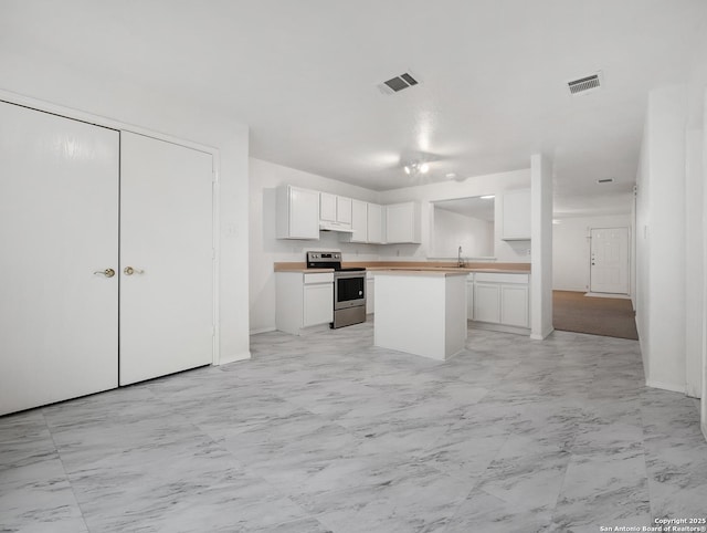 kitchen with visible vents, white cabinetry, light countertops, marble finish floor, and stainless steel electric range