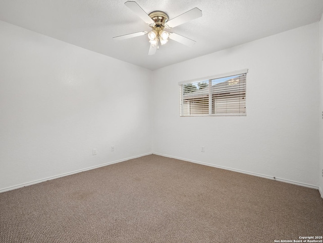 carpeted spare room with ceiling fan and baseboards