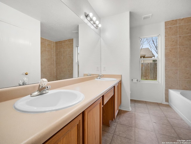 full bathroom with double vanity, a sink, visible vents, and a tub