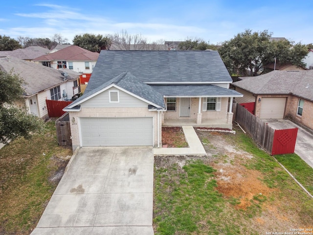 traditional-style house with an attached garage, a residential view, fence, and brick siding