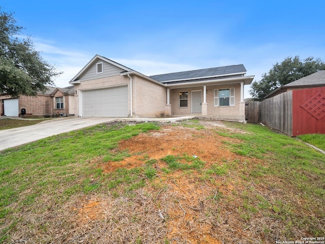 view of front of house featuring a garage, fence, concrete driveway, roof mounted solar panels, and a front yard