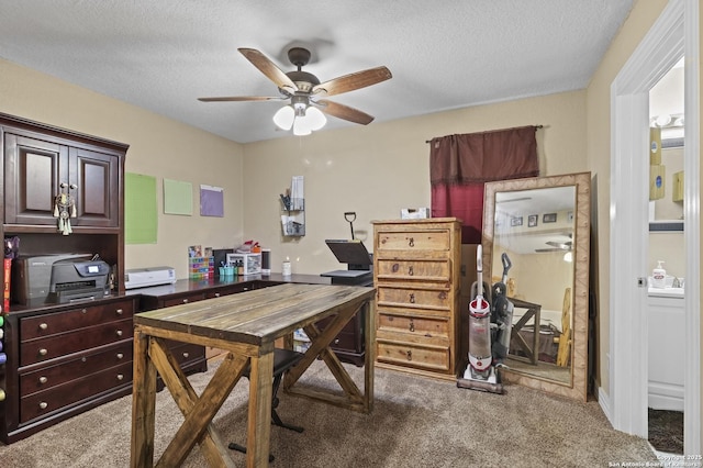 carpeted home office with a textured ceiling and a ceiling fan