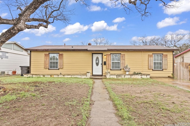 view of front of house featuring fence and a front lawn