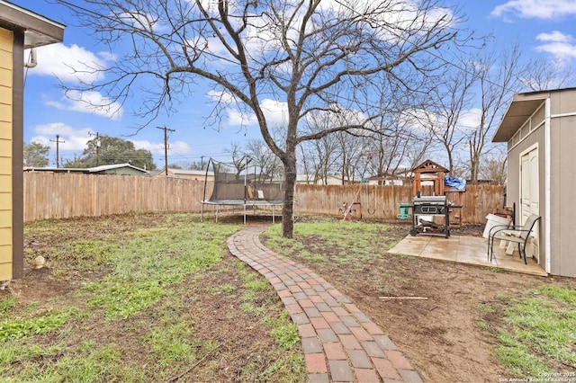 view of yard with a fenced backyard, a trampoline, a playground, and a patio