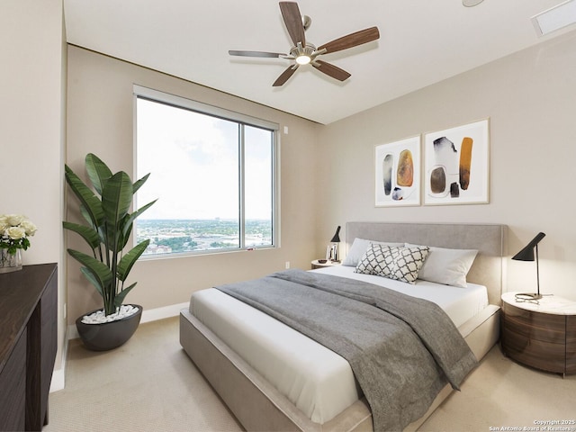 bedroom with light carpet, ceiling fan, visible vents, and baseboards