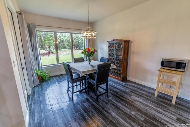 dining space featuring an inviting chandelier, baseboards, and dark wood-type flooring