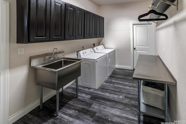 washroom with a sink, cabinet space, washing machine and dryer, and dark wood-type flooring