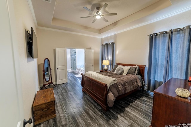 bedroom featuring ornamental molding, ceiling fan, dark wood-type flooring, and a raised ceiling