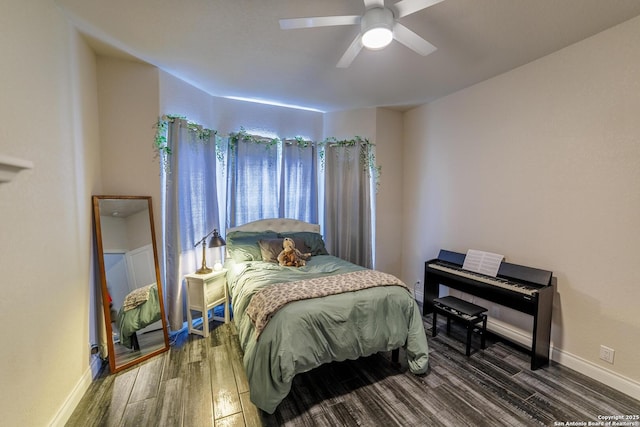 bedroom with dark wood-style floors, ceiling fan, and baseboards