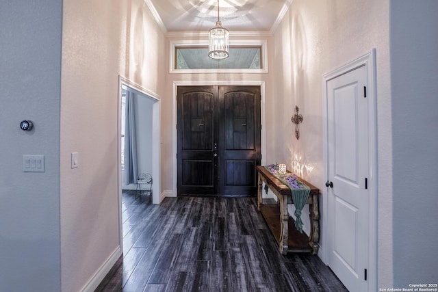 foyer featuring baseboards, dark wood-style flooring, and crown molding