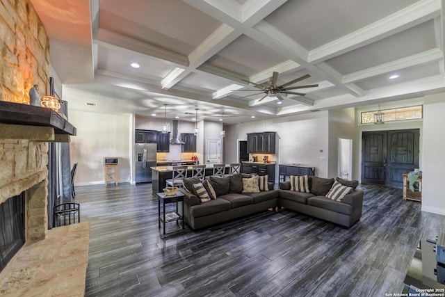 living area with coffered ceiling, a fireplace, dark wood-type flooring, and beam ceiling