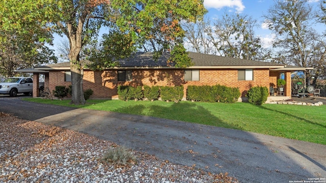 ranch-style home with brick siding and a front lawn