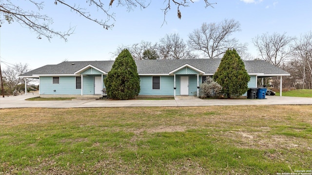 ranch-style home with concrete driveway and a front lawn