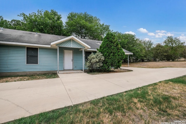 ranch-style home featuring driveway and a front yard