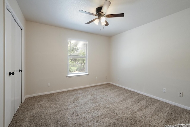 unfurnished bedroom featuring a ceiling fan, a closet, baseboards, and carpet flooring