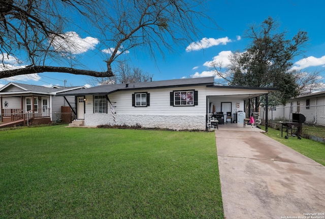 view of front facade featuring a carport, fence, concrete driveway, and a front yard