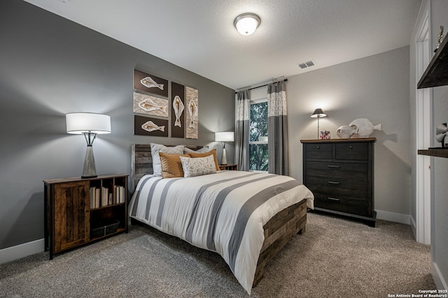 carpeted bedroom featuring baseboards, visible vents, and a textured ceiling