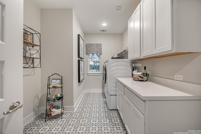 washroom featuring visible vents, separate washer and dryer, cabinet space, and baseboards