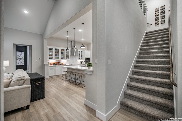 interior space with lofted ceiling, baseboards, wood finished floors, and recessed lighting