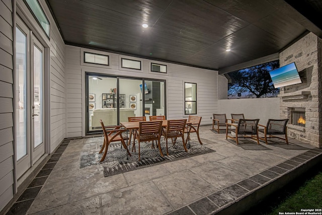 view of patio with an outdoor stone fireplace and outdoor dining area