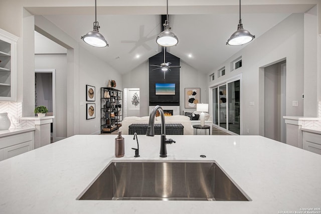 kitchen with open floor plan, light countertops, a sink, and decorative light fixtures