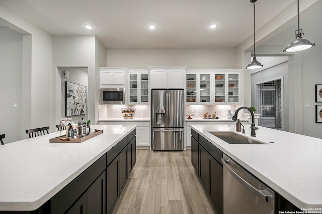 kitchen with glass insert cabinets, stainless steel appliances, and light countertops