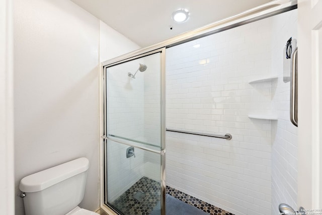 bathroom featuring a shower stall and toilet