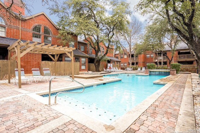 pool with a patio area, fence, and a pergola