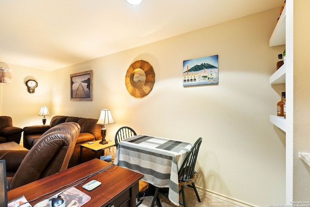 dining space featuring light carpet and baseboards