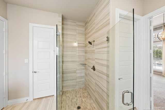 full bathroom featuring a stall shower, baseboards, and an inviting chandelier