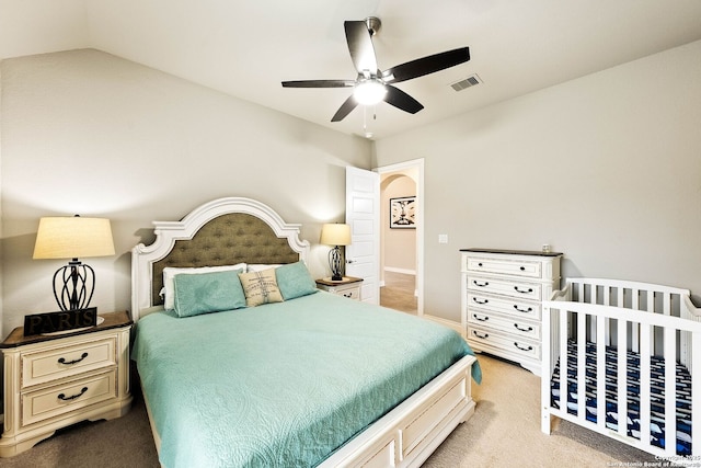 bedroom featuring visible vents, vaulted ceiling, light carpet, and ceiling fan