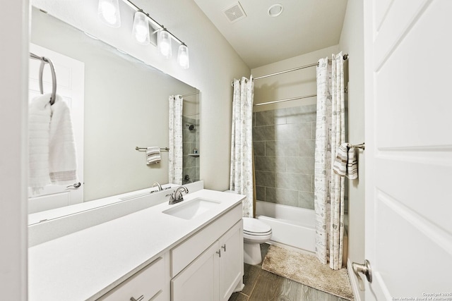 bathroom with visible vents, toilet, shower / bath combo with shower curtain, vanity, and wood finished floors