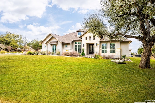 view of front facade with stone siding, a front lawn, and stucco siding