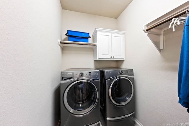 washroom featuring washing machine and dryer and cabinet space