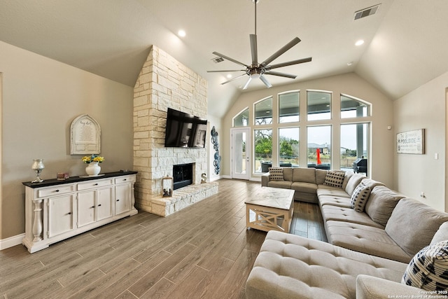 living area with baseboards, visible vents, a ceiling fan, light wood-style flooring, and a fireplace