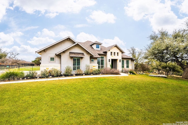 view of front of property with fence, a front lawn, and stucco siding