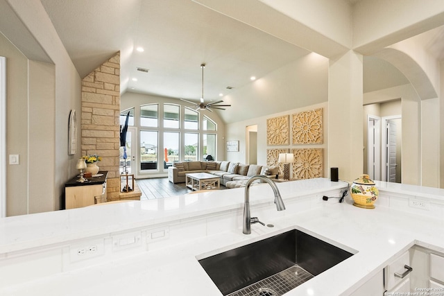 kitchen featuring visible vents, ceiling fan, open floor plan, light countertops, and a sink