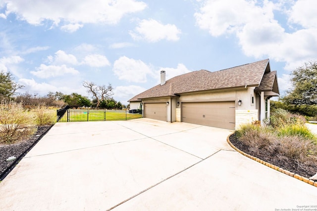 view of home's exterior featuring a garage, fence, driveway, roof with shingles, and a chimney