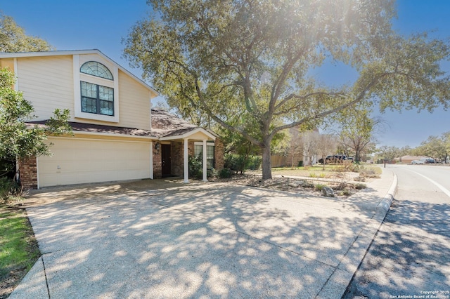 view of front of house with a garage, brick siding, and driveway