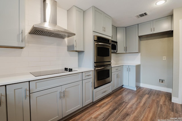 kitchen with visible vents, stainless steel appliances, light countertops, gray cabinetry, and wall chimney range hood