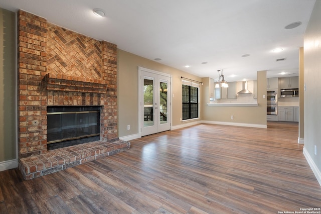 unfurnished living room featuring a fireplace, baseboards, and wood finished floors