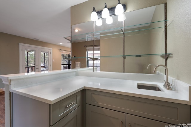 kitchen with french doors, a wealth of natural light, light countertops, gray cabinetry, and a sink