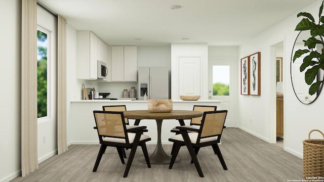 dining area with light wood-style flooring and baseboards